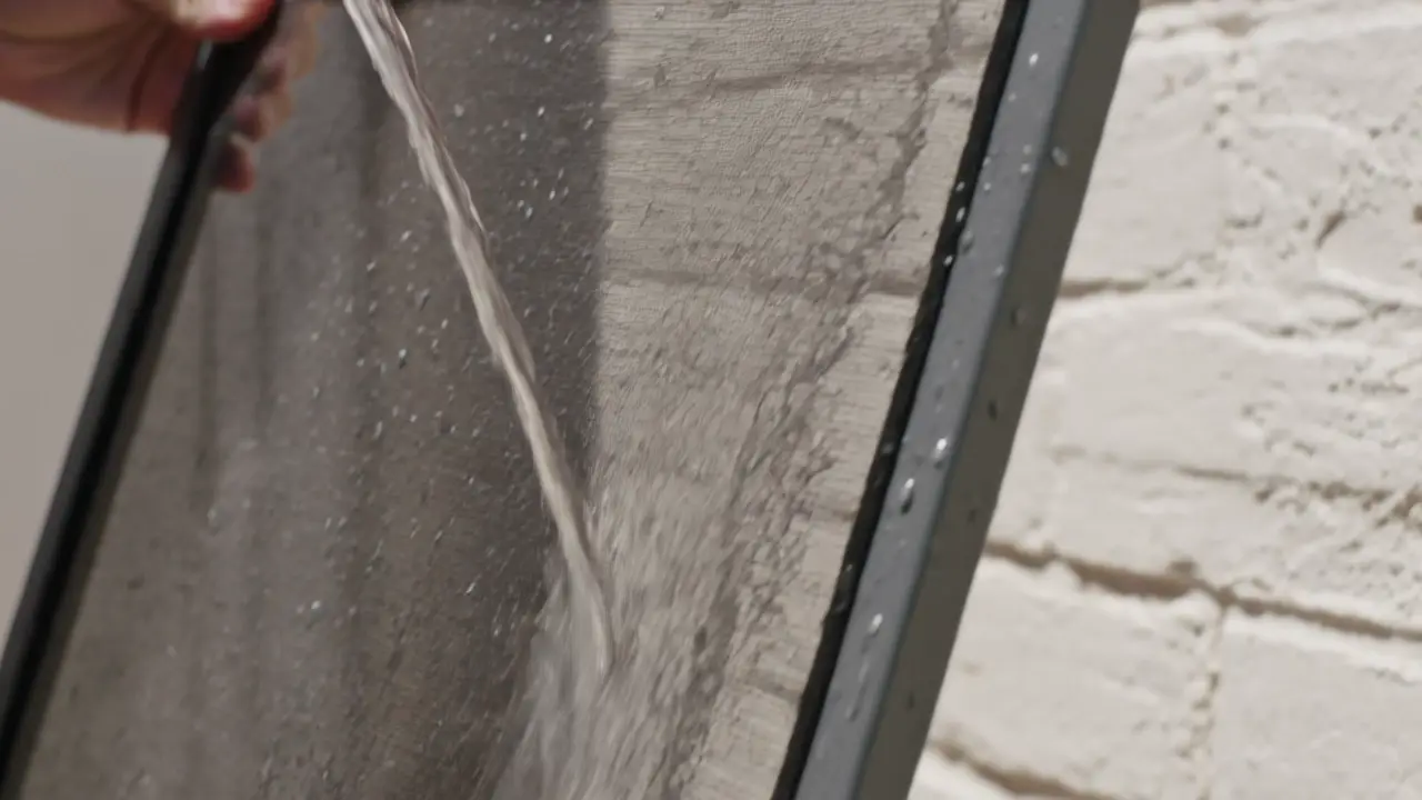 A window screen washed, rinsed, and set to dry in the sun.